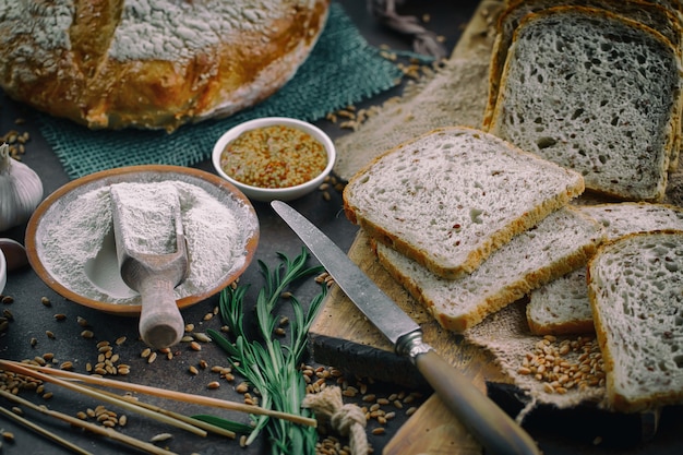 Świeży chleb na starym tle z kuchennymi akcesoriami na stole.