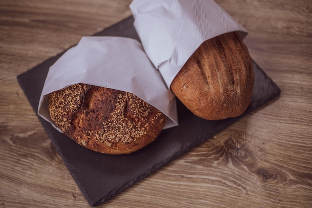 Świeży chleb w papierowej torbie na drewnianym stole Koncepcja produktów naturalnych chleb bezglutenowy