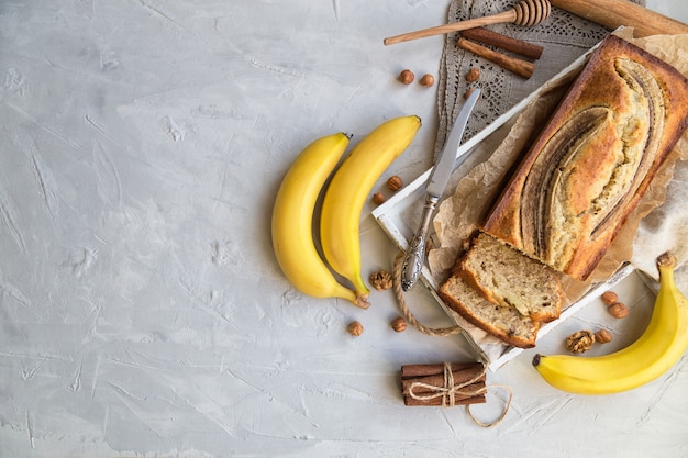 Świeży Domowy Chleb Bananowy W Białej Drewnianej Tacy Z Dodatkami Na Lekkim Betonie