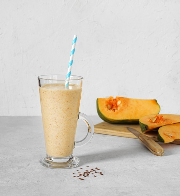 Świeży dyniowy i bananowy smoothie z lnianymi ziarnami na białej tła kopii przestrzeni