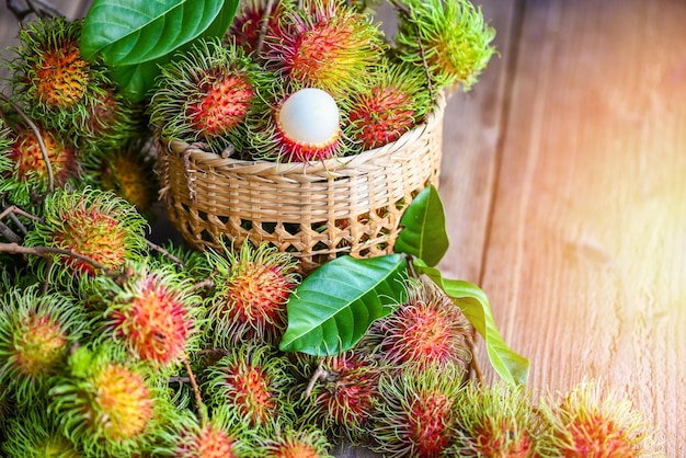 Świeży i dojrzały rambutan słodki tropikalny owoc rambutan obrany z liściem Rambutan owoc na tle kosza żniwa z ogrodu rambutan drzewo
