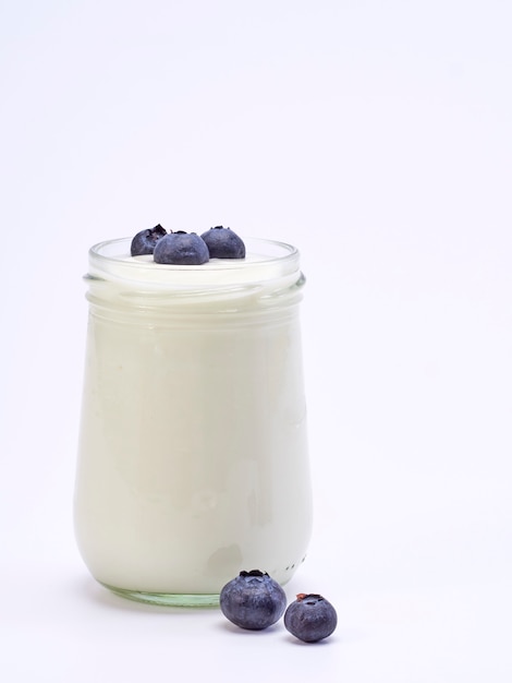 Świeży jagodowy jogurtu szkło na białym tle