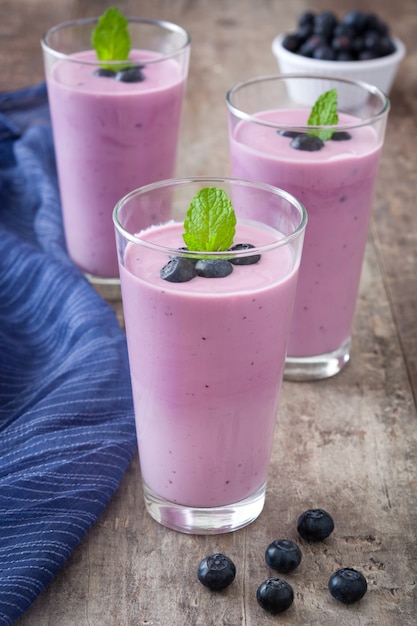 Świeży jagodowy smoothie w szkle na drewnianym stole