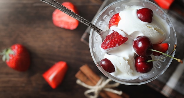 Świeży jogurt z jagodami. Lody w misce ze świeżymi i soczystymi truskawkami i wiśniami. Deser z czerwonymi jagodami.