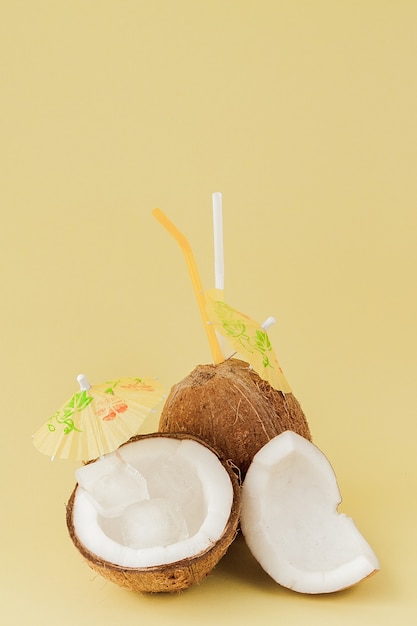 Świeży koktajl kokosowy ze słomkami na żółtym tle, kopia przestrzeń.