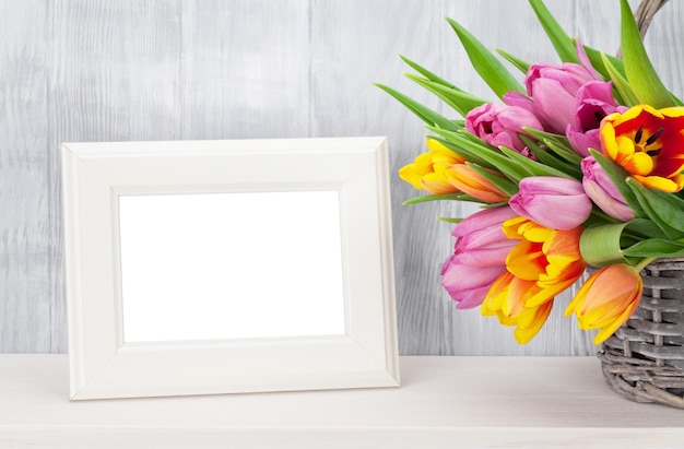 Świeży kolorowy bukiet tulipanów i ramka na zdjęcia