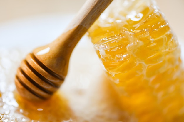 Świeży miód, miód pszczoła zdrowa żywność żółty słodki plaster miodu z drewnianą łyżką