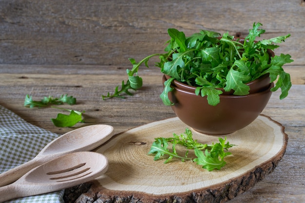 Świeży ogrodowy organicznie arugula, ruccola w pucharze na wieśniaka stole przygotowywającym dla sałatki. Vintage martwa natura