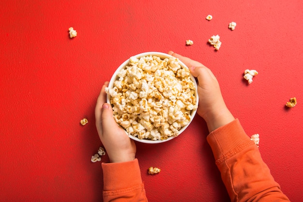 Świeży popcorn wylał się z miski na czerwono