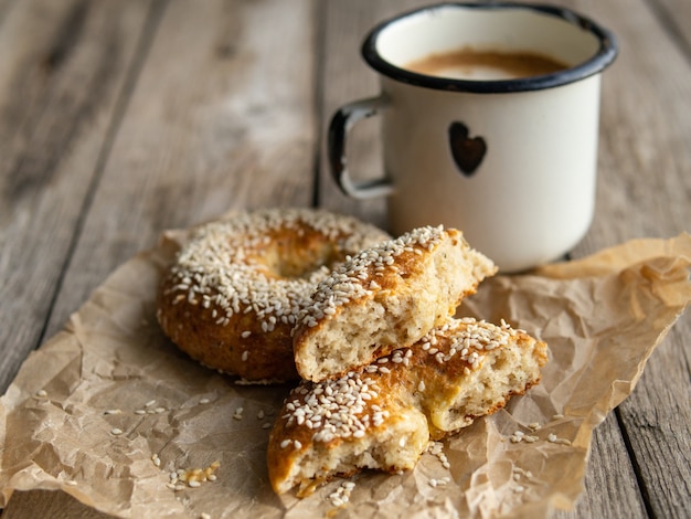 Zdjęcie Świeży ser pączki z sezamem na tle drewna z metalową białą filiżanką kawy.