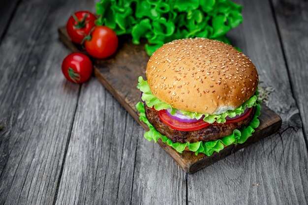 Świeży smakowity hamburger na drewno stole