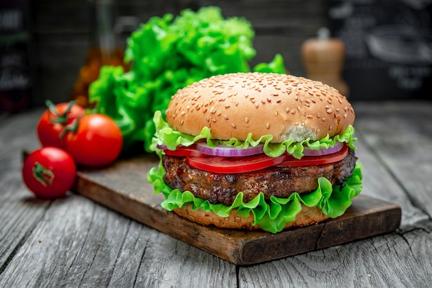 Świeży smakowity hamburger na drewno stole