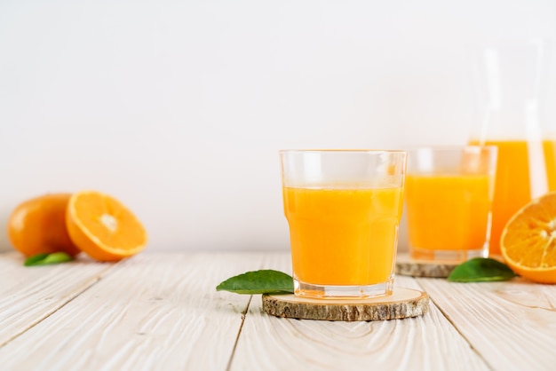 Świeży sok pomarańczowy na drewnianym tle