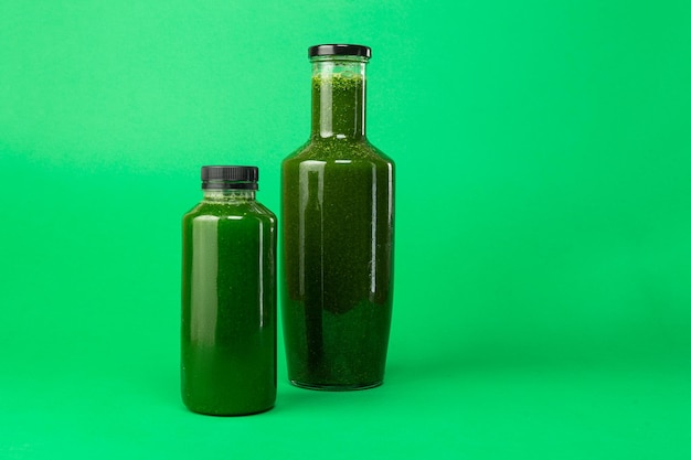 Zdjęcie Świeży sok ze szpinaku z selera w plastikowej i szklanej butelce sok na detoksykację zdrowej diety