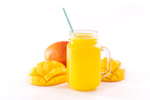 Świeży tropikalny sok z mango z piękną pokrojoną w kostkę miazgą i słomką w paski na białym tle stół z bliska wyciąć ścieżkę przycinającą