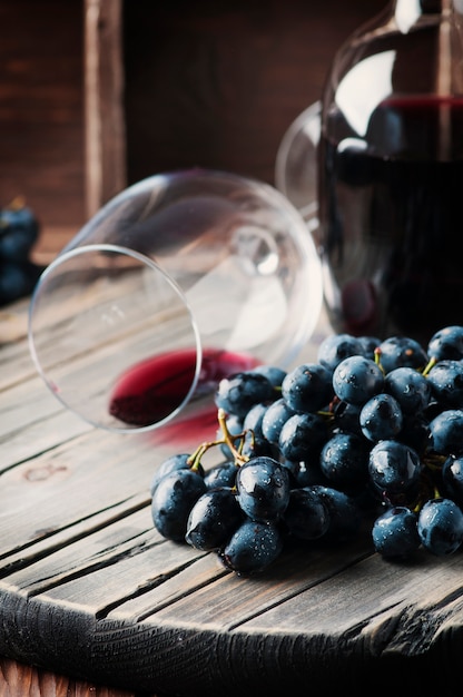 Świeży winogrono i czerwone wino na rocznika stole
