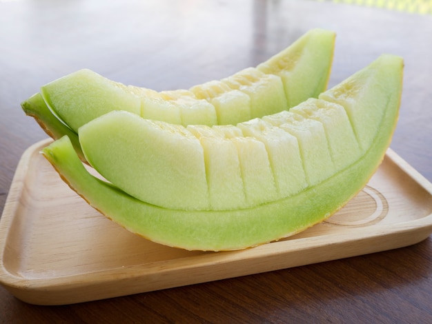 Świeży zielony melon slajd na płycie drewnianej