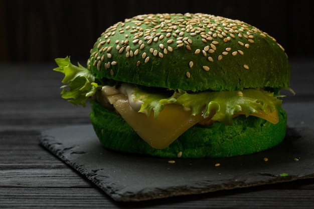 Zdjęcie Świeży zielony smakowity hamburger na czarnym tle