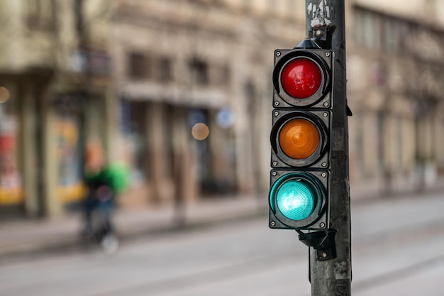 Sygnalizacja świetlna na skrzyżowaniu ulic z pięknym miastem bokeh z samochodami w tle