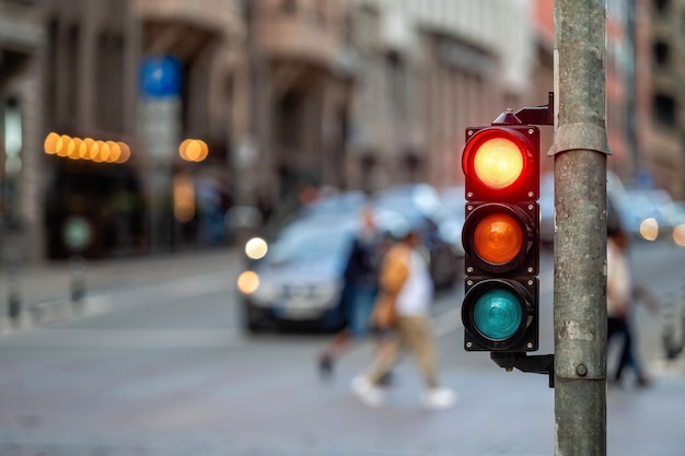 Sygnalizacja świetlna na skrzyżowaniu ulic z pięknym miastem bokeh z samochodami w tle