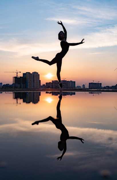 Sylwetka baleriny wykonujących odkryty podczas zachodu słońca. Pojęcie indywidualności, kreatywności i pewności siebie. Zdjęcie wysokiej jakości