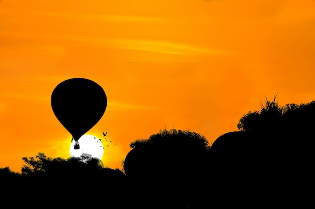 Zdjęcie sylwetka balonu na ogrzane powietrze na tle zachodu słońca