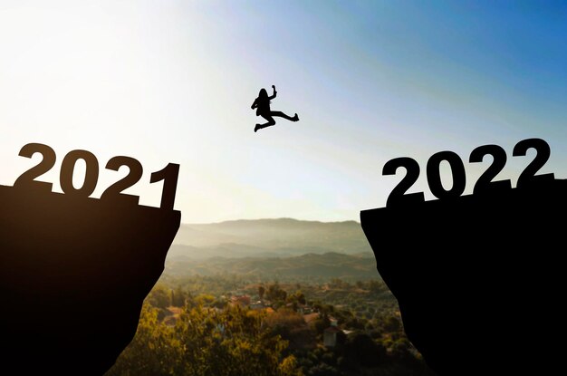 Sylwetka bizneswoman skaczącej ze skoczni 2021 na skocznię 2022. Szczęśliwego Nowego Roku 2022