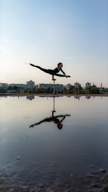 Sylwetka elastyczne dziewczyny dong handstand w podziale na tle nieba. Koncepcja indywidualności, kreatywności i wybitności.