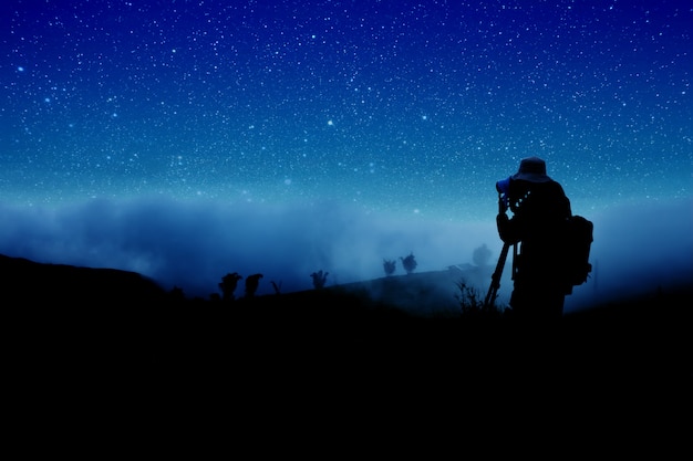 Sylwetka fotograf strzela nocnych gwiazdy