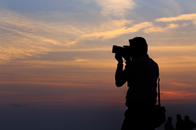 Sylwetka fotografa na zachód słońca