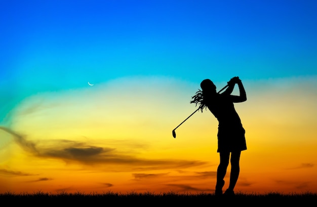 Zdjęcie sylwetka golfista gry w golfa podczas piękny zachód słońca