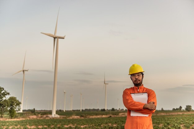 Sylwetka inżyniera mężczyzny pracującego i trzymającego raport w elektrowni wiatrowej na farmie elektrowni wiatrowej na górskich mieszkańcach Tajlandii