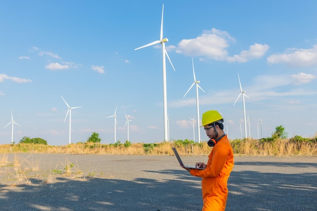 Sylwetka inżyniera mężczyzny pracującego i trzymającego raport w elektrowni wiatrowej na farmie elektrowni wiatrowej na górskich mieszkańcach Tajlandii