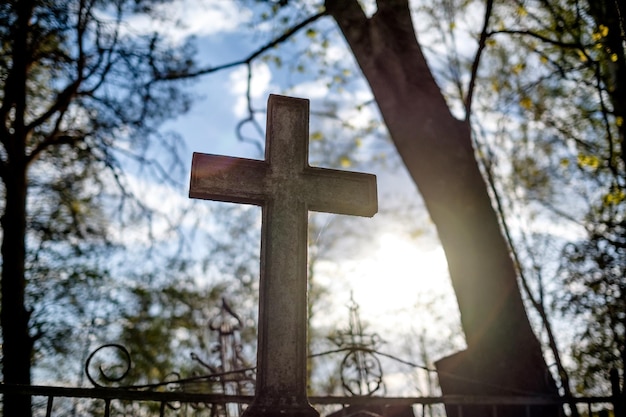 Sylwetka krzyża o zachodzie słońca na cmentarzu