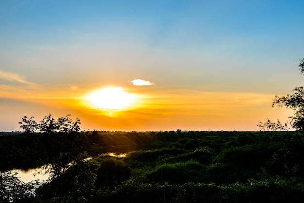 Sylwetka lasu z dużą rzeką o zachodzie słońcapiękny kolorowy zmierzch wieczorem styl obrazu HDR