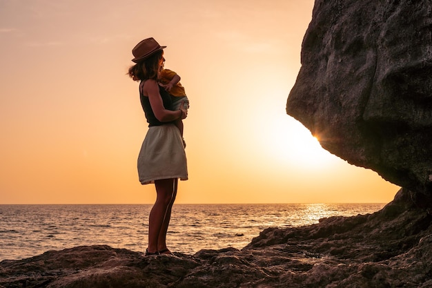 Sylwetka matki i syna przytulających dziecko o zachodzie słońca na plaży Tacoron na Wyspach Kanaryjskich El Hierro koncepcja wakacji pomarańczowy zachód słońca