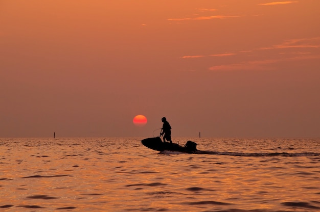 Sylwetka Mężczyzna Jeżdżenia Jetski Na Morzu Z Podczas Zmierzchu