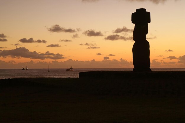 Sylwetka Moai w Ahu Tahai przed zachodem słońca niebo i Ocean Spokojny, stanowisko archeologiczne na Wyspie Wielkanocnej, Chile