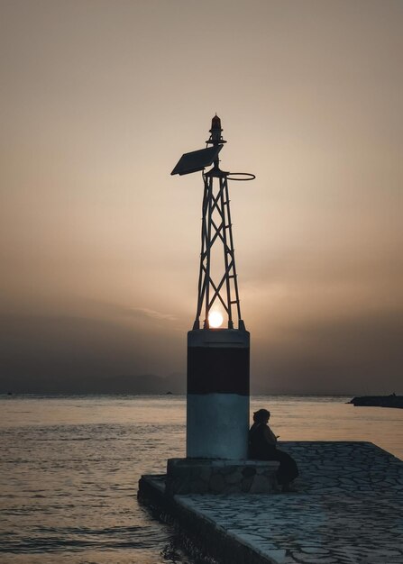 Sylwetka osoby na zachodzie słońca w porcie Sivota Thesprotia Grecja