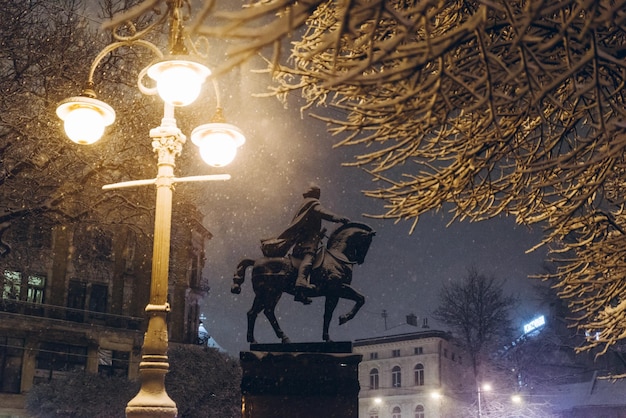 Sylwetka pomnika w nocy w pobliżu światła miasta