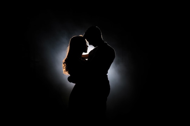 Sylwetka romantycznej pary tańczącej i cieszącej się w ciemności