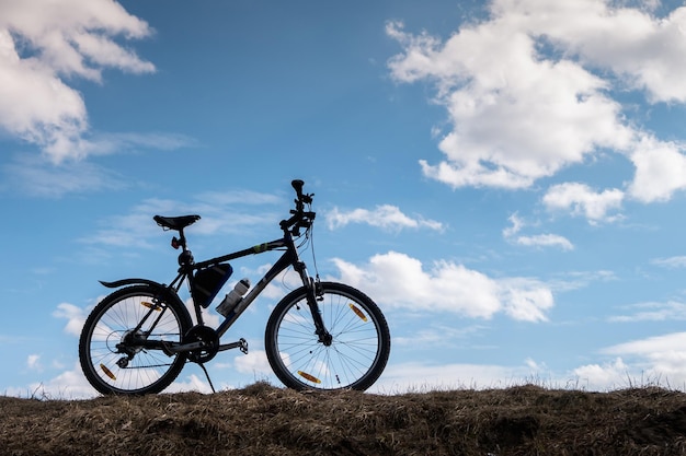 Sylwetka roweru w błękitne niebo z chmurami symbol niezależności i wolności