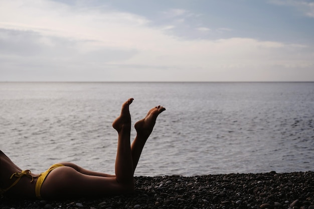 Sylwetka szczupłej seksownej dziewczyny leżącej na plaży nad morzem latem na wakacjach