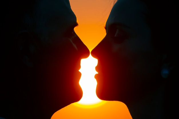 Sylwetka w profilu twarzy mężczyzny i kobiety na tle zachodzącego słońca. miłość i romans w związku kochającej się pary
