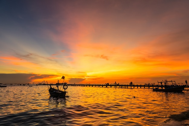 Sylwetki Mała łódź rybacka przy brzeg w zmierzchu przy uderzenia Phra plażą, sriracha choburi, Thailand