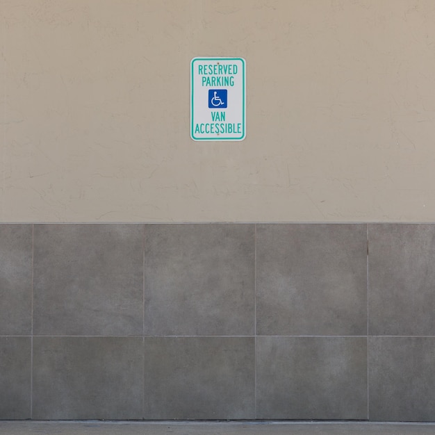 Symbole niepełnosprawności na parkingu przy drodze asfaltowej zarezerwowane dla osób niepełnosprawnych lub osób niepełnosprawnych