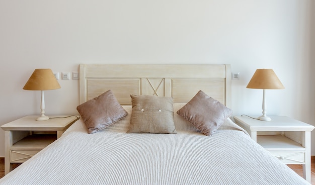 Zdjęcie sypialnia w nowoczesnym stylu z łóżkiem i poduszkami. przedni widok.