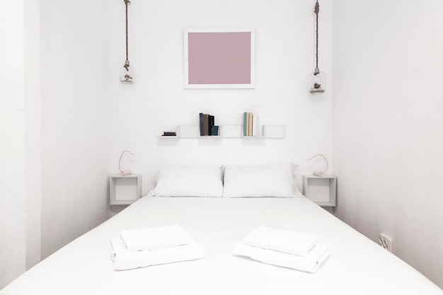Sypialnia z łóżkiem king size białe lampy ledowe białe poduszki i poduszki oraz dopasowane ręczniki