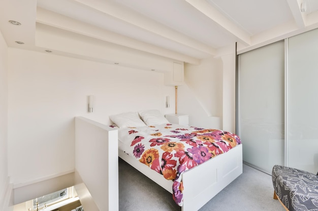 Sypialnia z miękkim łóżkiem nakrytym kwiecistą narzutą