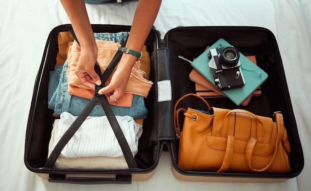 Sypialnia z walizką podróżną i ręce kobiety pakującej się na wakacje w europie lub przygodową podróż turystyczną Łóżko hotelowe i fotograf z bagażem, ubraniami i aparatem w madrycie